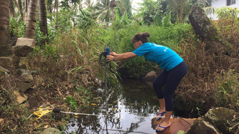 Staff member from the American Samoa Coral Reef Advisory Group measuring streamflow to provide flow information used to calculate surface water nitrogen loading to the coastal zone.