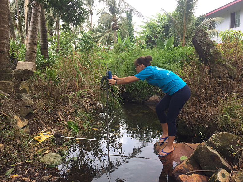 Staff member from the American Samoa Coral Reef Advisory Group measuring streamflow to provide flow information used to calculate surface water nitrogen loading to the coastal zone.